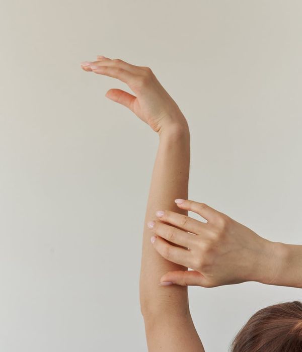 Woman in a serene yoga pose against a soft cream background.